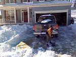The wife shovelling out the driveway.
